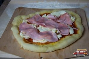 pizza z szynką przed upieczeniem