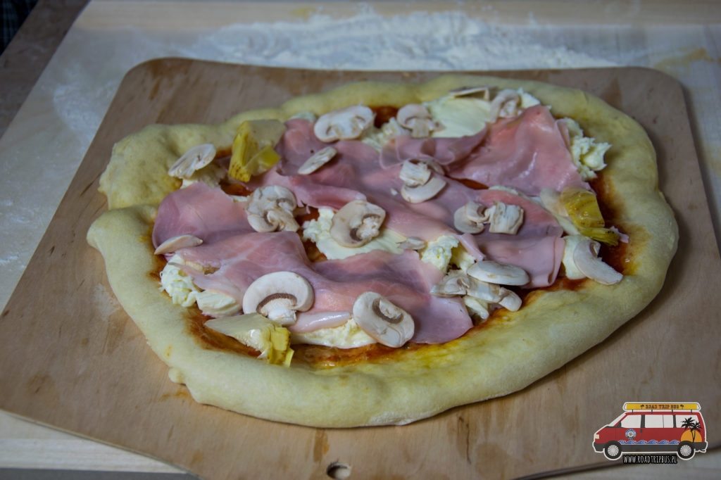 pizza z szynką i pieczarkami przed upieczeniem