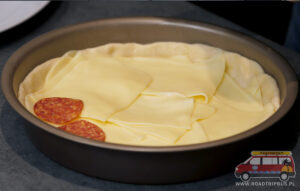 układanie składników na chicago deep dish pizza
